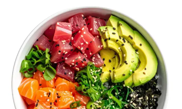Un bol de poke coloré avec du thon, du saumon, de l'avocat et des algues, prêt à être nappé d'une délicieuse sauce poke bowl.