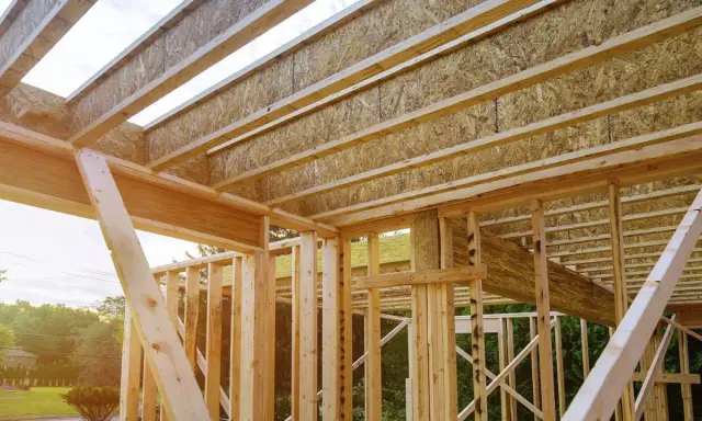 Estructura de madera de una casa en construcción, mostrando las partes de un apeo y vigas del techo.