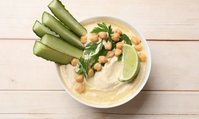 Krämig hummus med kikärtor, persilja, gurkstavar och lime. Ett enkelt hummus recept för en god dipp.