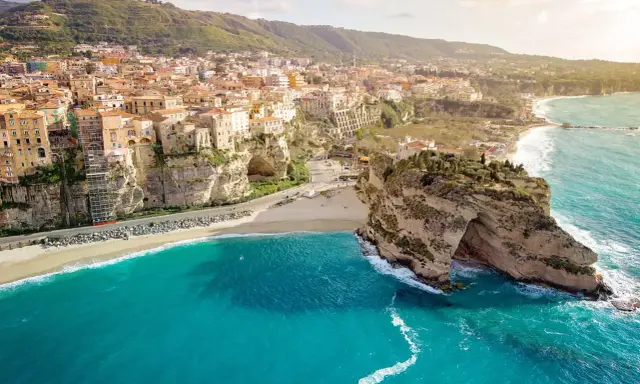 Panoramica mozzafiato delle calabria spiagge con case colorate aggrappate alle scogliere e un mare cristallino.