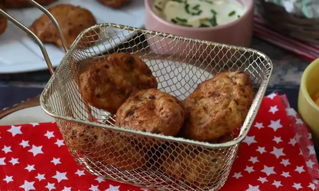 Gyldene chicken nuggets i en friteringskurv, nylagade i airfryer. Serveras med en krämig dipp.