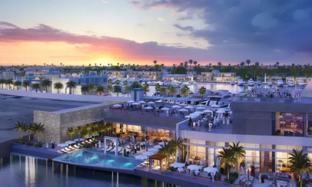 Un moderno complesso sul Jeddah port con piscina a sfioro, ristoranti all'aperto e yacht ormeggiati al tramonto.