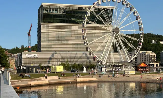 Oslo czy warto? Muzeum Muncha i diabelski młyn na nabrzeżu, ludzie odpoczywają nad wodą.