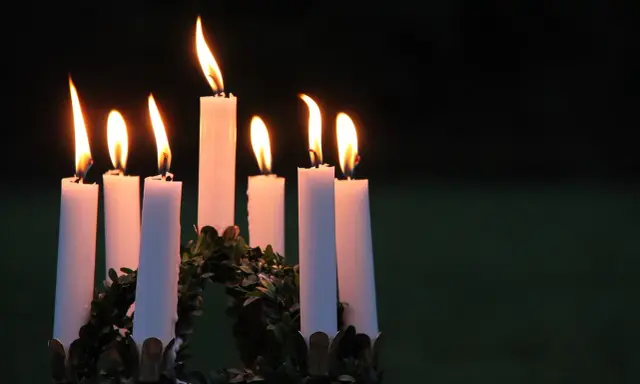 Sju ljus brinner i en krans, en påminnelse om vad betyder namnet Lucia: ljus.