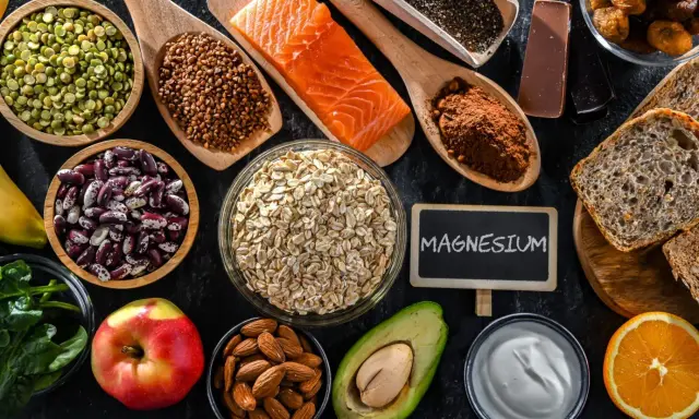 Magnesium-reiche Lebensmittel wie Lachs, Haferflocken, Nüsse und dunkle Schokolade zeigen die Wirkung von Magnesium auf den Körper.