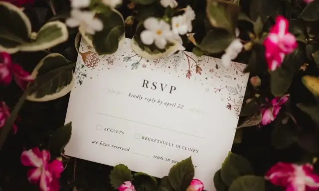 Karta RSVP z kwiatowym wzorem wśród zieleni i różowych kwiatów.