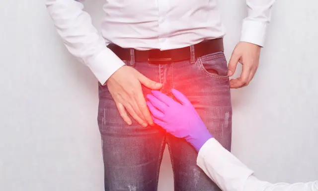 Ręka w rękawiczce bada obszar podrażnienia. Szukasz domowych sposobów na ból jądra?