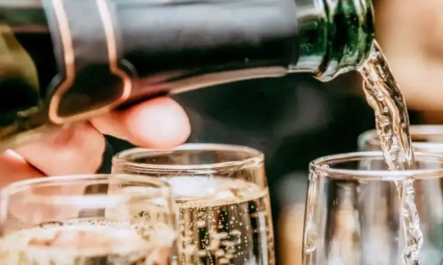 Un verre se remplit de bulles fines, promesse du meilleur champagne rosé. Une célébration pétillante commence.