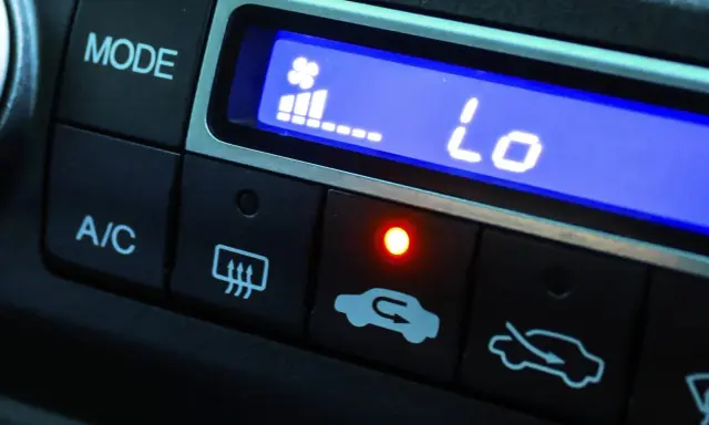 El aire acondicionado del coche muestra "Lo" indicando baja temperatura. El ventilador está al mínimo y la luz roja está encendida.