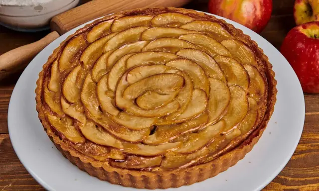 Tarta de manzana dorada, con finas láminas de manzana dispuestas en espiral sobre una base crujiente. ¡Perfecta para disfrutar!