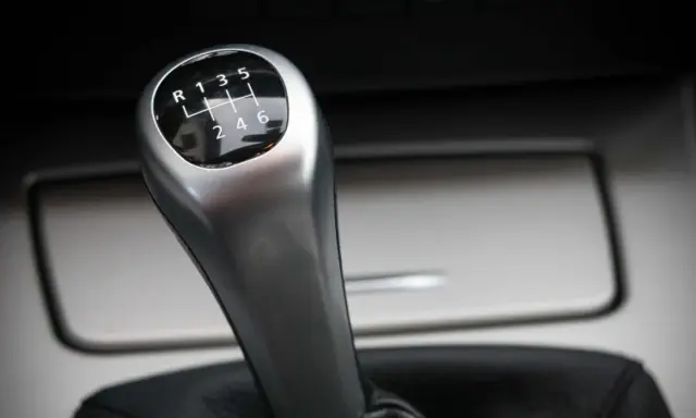 Palanca de cambios de un coche manual, con el patrón de marchas visible. Parece que el cambio de marchas roto impide seleccionar la marcha deseada.