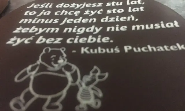 Czekoladowy medalion z cytatem Kubusia Puchatka i rysunkiem Kubusia i Prosiaczka.