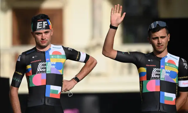 Zwei Radfahrer im bunten Trikot, bereit für den Giro d'Italia. Einer winkt lässig.