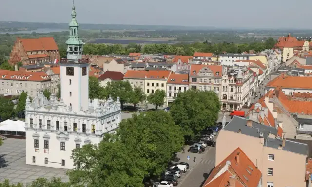 Widok na rynek w Chełmnie z ratuszem i wieżą. W tle kamienice i zieleń, idealne chełmno atrakcje.