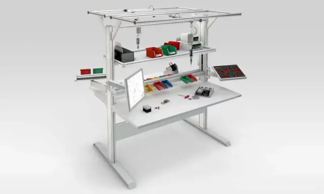 Poste de travail industriel optimisé pour la norme ergonomie, avec écran, bacs de rangement et outils organisés pour une efficacité maximale.