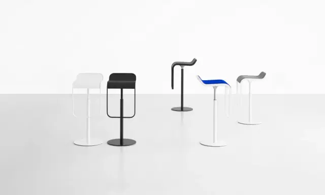 Cinque sgabelli LEM di design, bianchi, neri, blu e grigi, su sfondo bianco.