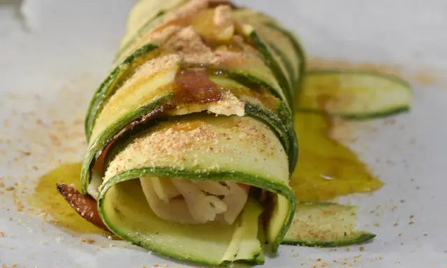 Delizioso rotolo di zucchine, avvolto con cura e cosparso di pangrattato e olio d'oliva. Un piatto leggero e gustoso.