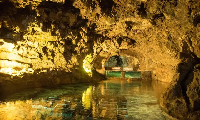 Beleuchtete Höhlen von São Vicente mit einem ruhigen Wasserbecken und Aquarien.