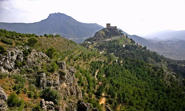 Castillo en la cima de una colina, rodeado de bosques y montañas. Un lugar perfecto que ver en Segura de la Sierra.