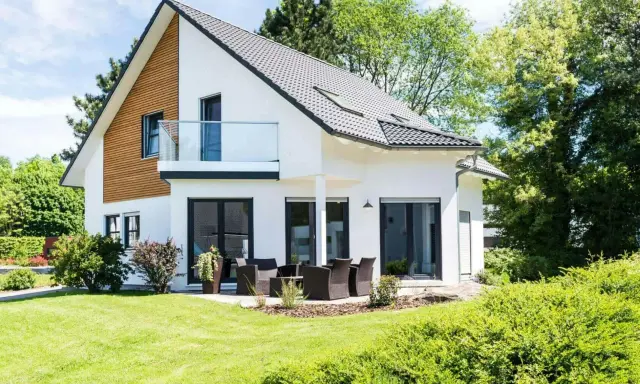 Maison moderne avec balcon, terrasse et jardin. Un projet de construction de maison qui respecte le budget.