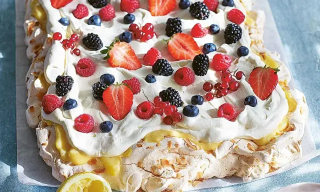 En stor pavlova med grädde och färska bär, perfekt för påskfirandet.