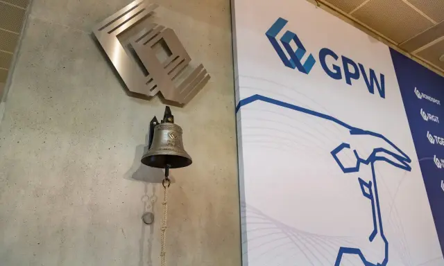 Dzwonek giełdowy GPW, symbolizujący rozpoczęcie obrotu, obok logo giełdy.