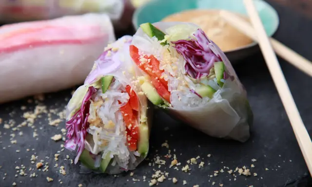 Frische, bunte Sommerrollen mit Reisnudeln, Gurke, Tomate und Rotkohl, bestreut mit Erdnüssen. Perfekt für einen leichten Snack.