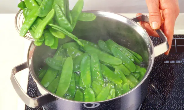 Zuckerschoten werden in einem Topf mit kochendem Wasser blanchiert. Ein einfaches Rezept für frische Zuckerschoten.