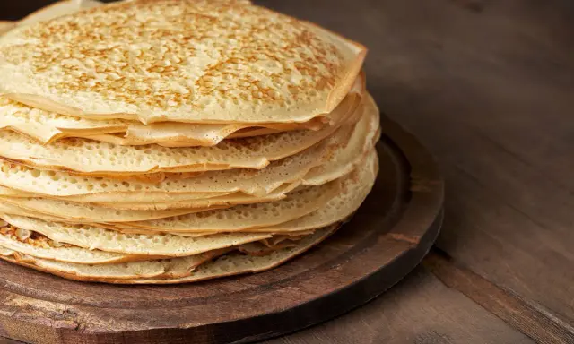 En hög med gyllene pannkakor, redo att serveras. Perfekt för ett enkelt pannkakor recept.