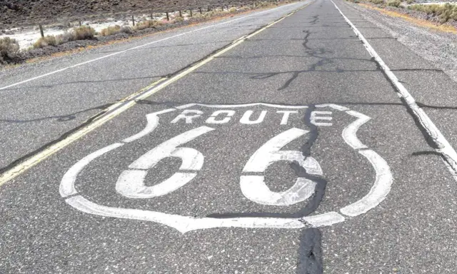La Route 66, symbole de liberté et d'aventure, s'étend sur l'asphalte craquelé. Sa signification est immense pour les voyageurs.