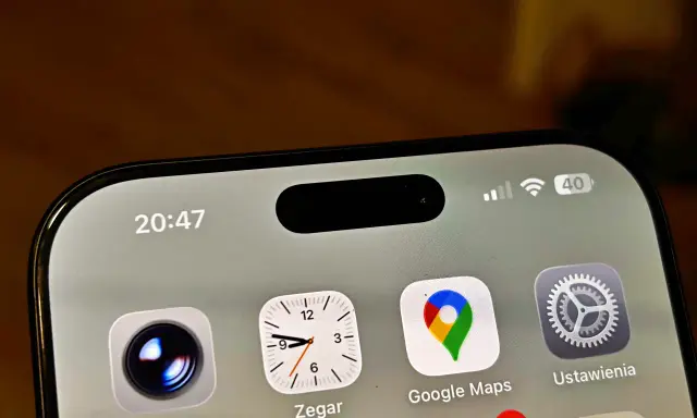 Ekran iPhone z widoczną dynamiczną wyspą, ikonami Aparat, Zegar, Google Maps i Ustawienia. Czas 20:47.