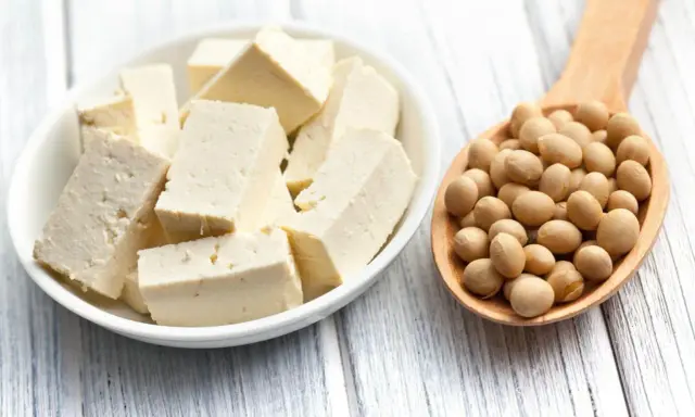 Kostki białego tofu w miseczce i łyżka pełna ziaren soi. Idealne składniki na zdrowe posiłki, w tym tofu dla niemowlaka.