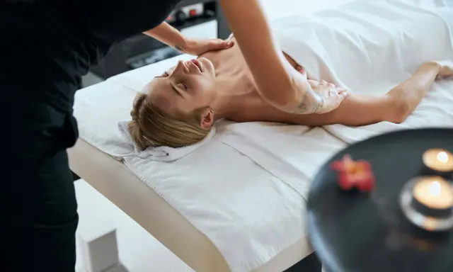 Relaks po masażu. Terapeuta stosuje techniki masażu klasycznego, aby rozluźnić mięśnie i przynieść ulgę.