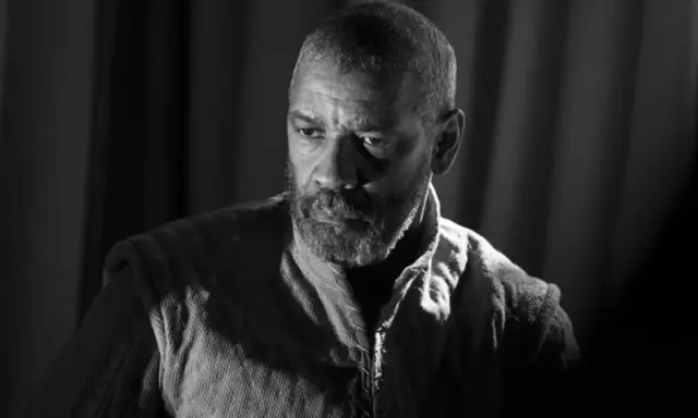 Denzel Washington jako Makbet w mrocznej epoce. Jego spojrzenie zdradza wewnętrzne rozterki i ambicje.