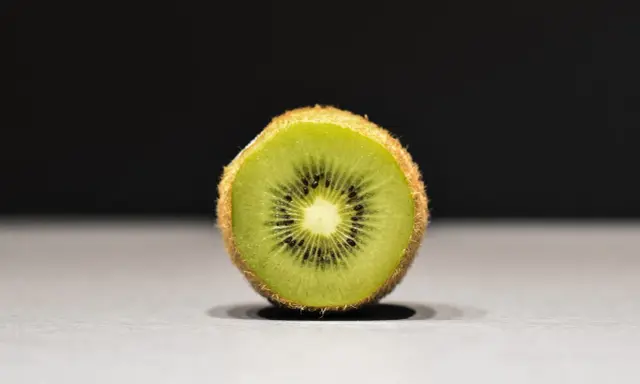 Połówka kiwi, idealna na keto, z widocznymi czarnymi pestkami i zielonym miąższem.
