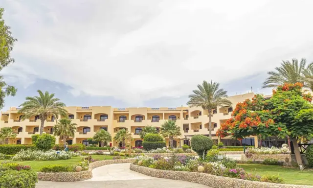 Piękny hotel z palmami i kwitnącym drzewem. Wiele pozytywnych blend elphistone resort opinie potwierdza urok tego miejsca.