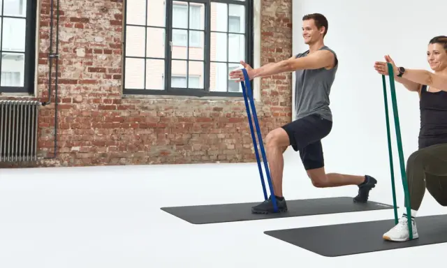 Mann und Frau machen Ausfallschritte mit Widerstandsbändern. Effektives HIIT Training für zu Hause.