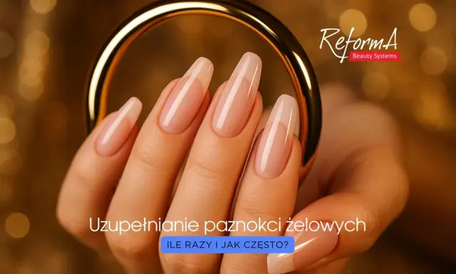 Dłoń z idealnie wykonanymi paznokciami żelowymi, prezentującymi prawidłową budowę. Złota obręcz podkreśla elegancję.