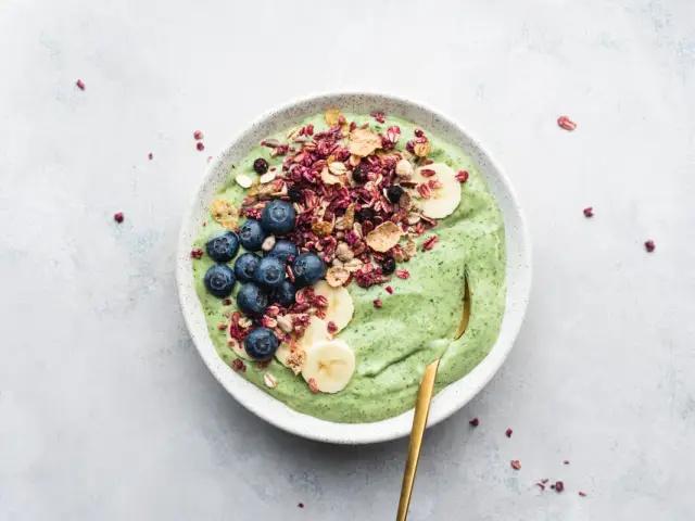Grön smoothiebowl med blåbär, banan och granola. Perfekt för frukost tips!