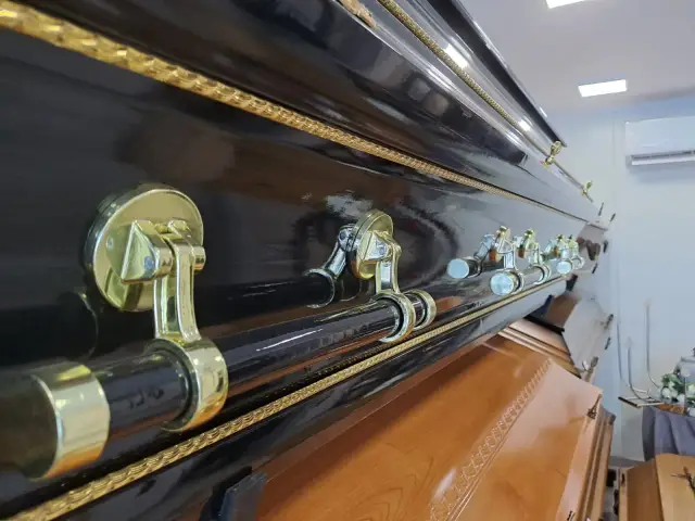 Elegancka, czarna trumna z ozdobnymi uchwytami. Warto pomyśleć, jak napisać ostatnie pożegnanie, gdy przyjdzie taki moment.