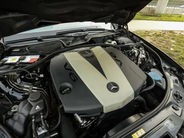 Silnik V6 om642 Mercedesa z otwartą maską. Widoczny akumulator, płyny i elementy osprzętu.