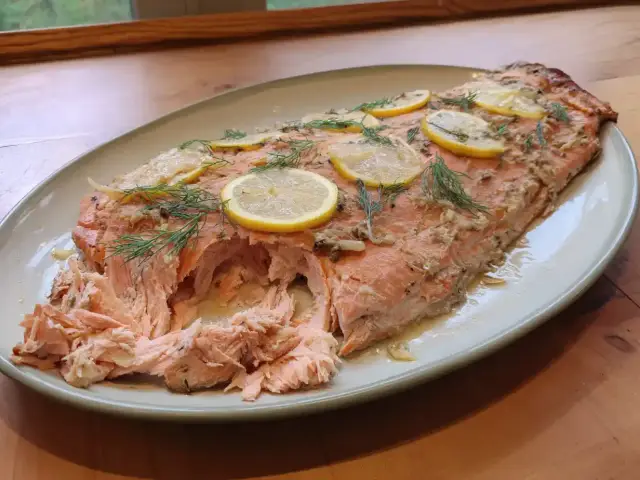 En saftig hel fisk i ugn, toppad med citronskivor och dill. Perfekt för en härlig middag.