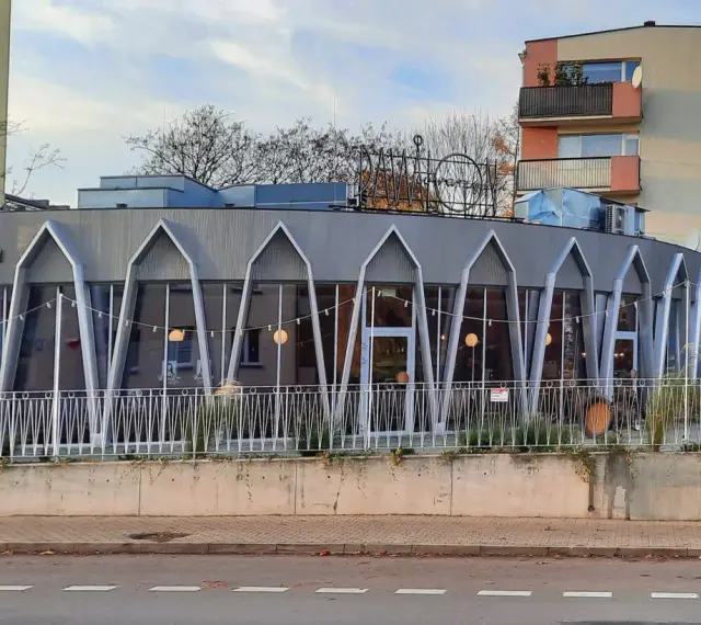 Charakterystyczna modernistyczna architektura budynku z przeszkloną fasadą i geometrycznymi elementami.