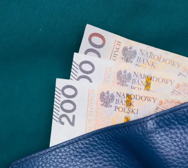 Trzy banknoty po 200 zł w granatowym portfelu. Zastanawiasz się, ile wynosi zasiłek celowy?