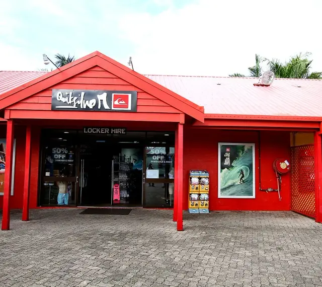Sklep Quiksilver, znanej firmy odzieżowej dla surferów, z czerwonym logo i ofertą "Locker Hire".