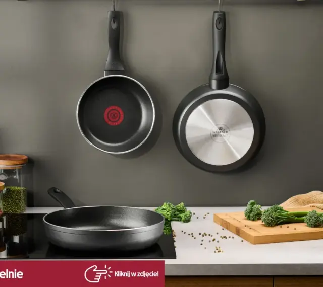 Dwie patelnie wiszące, jedna z logo Tefal, druga Gerlach. Na blacie patelnia, słoiki z makaronem i przyprawami, deska z brokułami. Czy patelnie Tefal można myć w zmywarce? Sprawdź!