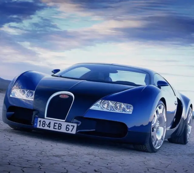 Niebieski Bugatti Veyron na pustynnym tle pod błękitnym niebem.