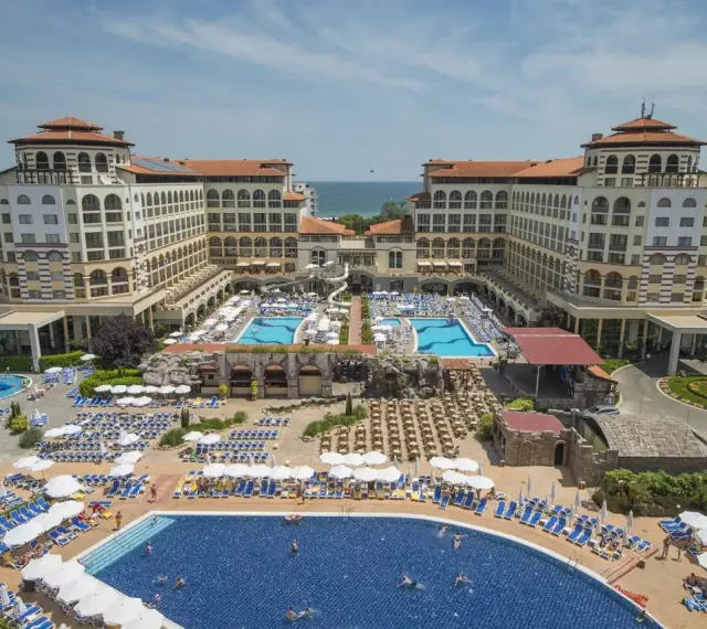 Wielki kompleks hotelowy z basenami i leżakami, idealny na bułgaria wczasy all inclusive.