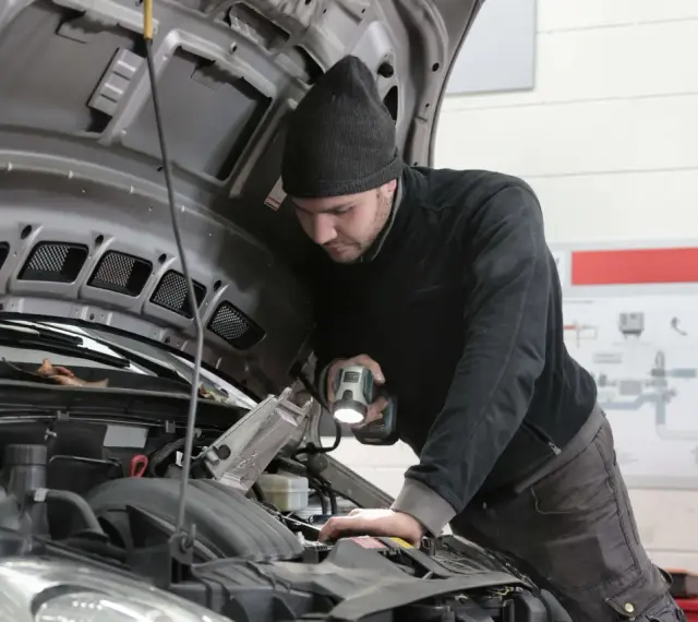 Mechanik bada silnik, szukając objawów uszkodzenia przegubu zewnętrznego.