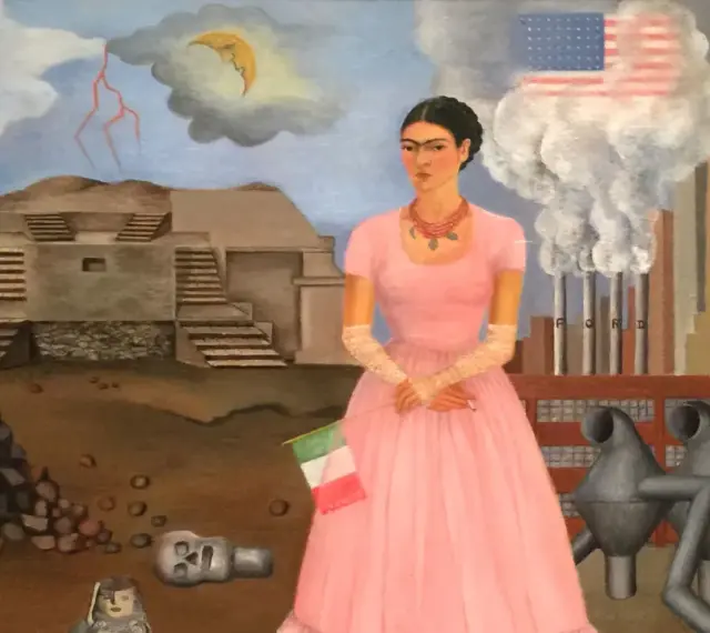 Frida Kahlo w różowej sukni, z flagą Włoch, na tle fabryki Forda i piramidy. Jej niepełnosprawność jest widoczna w jej postawie.